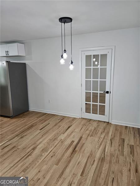 775 Lee Andrews Ave, Atlanta, GA 30315 - unfurnished dining area with light wood-style flooring and baseboards