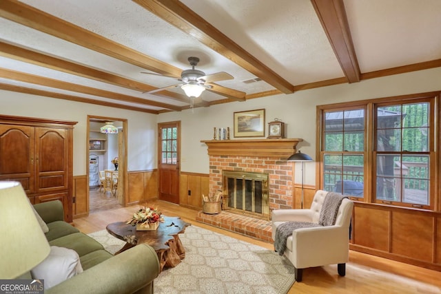 3311 Creek Hollow Dr, Marietta, GA 30062 - living room with a fireplace, beamed ceiling, wainscoting, light wood-type flooring, and ceiling fan