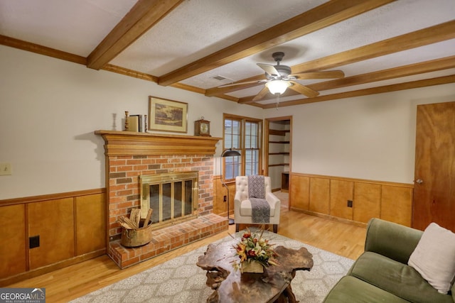 3311 Creek Hollow Dr, Marietta, GA 30062 - living room with beamed ceiling, wainscoting, wood finished floors, a brick fireplace, and a ceiling fan