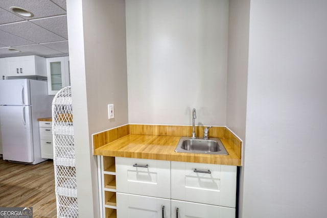 3311 Creek Hollow Dr, Marietta, GA 30062 - kitchen with freestanding refrigerator, white cabinets, wood finished floors, glass insert cabinets, and a drop ceiling