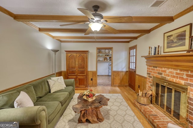 3311 Creek Hollow Dr, Marietta, GA 30062 - living area featuring wainscoting, beam ceiling, light wood-type flooring, a ceiling fan, and a textured ceiling