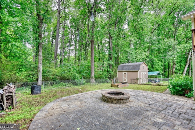3311 Creek Hollow Dr, Marietta, GA 30062 - fenced backyard featuring an outdoor fire pit, a patio, a shed, and a wooded view