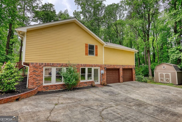 3311 Creek Hollow Dr, Marietta, GA 30062 - view of property exterior featuring a storage shed, concrete driveway, brick siding, a garage, and view of scattered trees