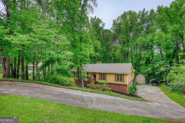 3311 Creek Hollow Dr, Marietta, GA 30062 - view of front of property with covered porch, a storage unit, driveway, brick siding, and a chimney