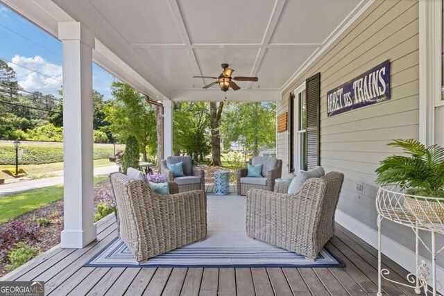 wooden deck with ceiling fan, covered porch, and outdoor lounge area