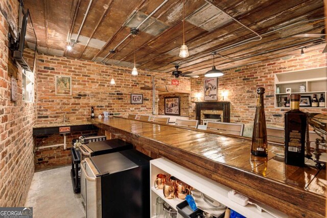 indoor dry bar with brick wall, finished concrete floors, ceiling fan, fridge, and wood ceiling