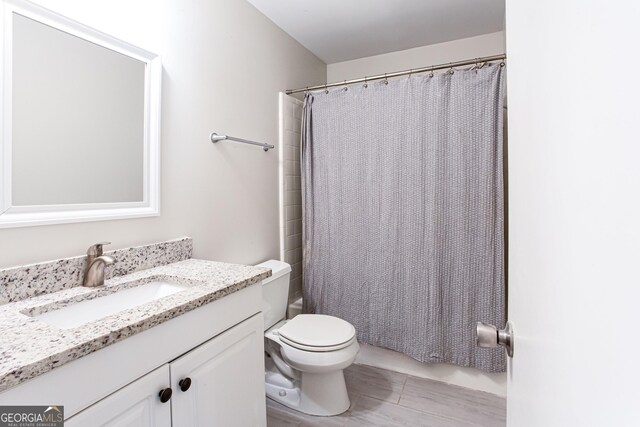 1700 Jimmy Daniel Rd, Watkinsville, GA 30677 - bathroom featuring toilet, vanity, shower / bath combination with curtain, and wood finished floors
