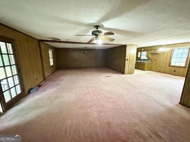 310 Advantage Ln, Swainsboro, GA 30401 - unfurnished living room featuring wooden walls, ceiling fan, and light colored carpet