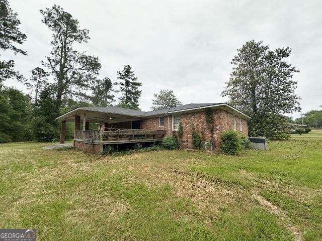 310 Advantage Ln, Swainsboro, GA 30401 - rear view of property featuring a lawn, a wooden deck, and brick siding