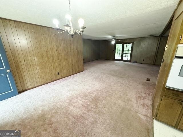 310 Advantage Ln, Swainsboro, GA 30401 - unfurnished room with a chandelier, light colored carpet, ceiling fan, and wooden walls