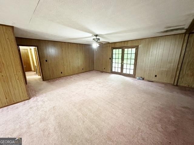 310 Advantage Ln, Swainsboro, GA 30401 - spare room featuring a ceiling fan, french doors, wooden walls, and light carpet