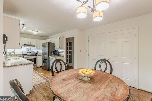 4314 Arbor Bridge Ct, Marietta, GA 30066 - dining space featuring light wood-style floors, a chandelier, and a textured ceiling