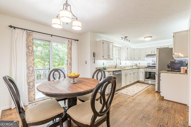 4314 Arbor Bridge Ct, Marietta, GA 30066 - dining room featuring light wood-type flooring and a textured ceiling