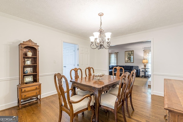 4314 Arbor Bridge Ct, Marietta, GA 30066 - dining space with crown molding, wood finished floors, a chandelier, and a textured ceiling