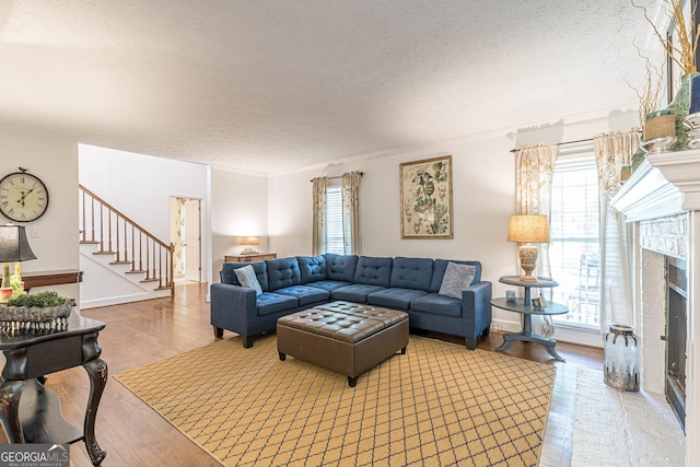 4314 Arbor Bridge Ct, Marietta, GA 30066 - living area with a textured ceiling, wood finished floors, stairway, a fireplace, and crown molding