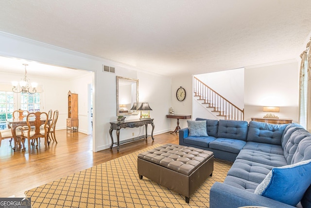 4314 Arbor Bridge Ct, Marietta, GA 30066 - living room with a chandelier, crown molding, light wood-style flooring, and stairs