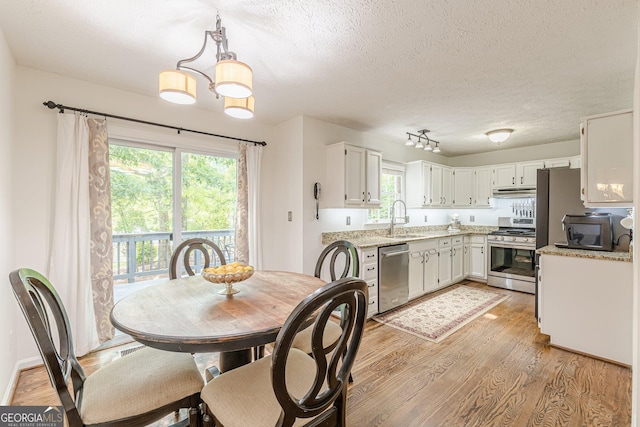 4314 Arbor Bridge Ct, Marietta, GA 30066 - dining space with light wood-style floors, a chandelier, and a textured ceiling