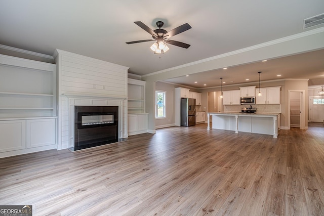 1482 Alcovy Station Rd, Covington, GA 30014 - unfurnished living room featuring crown molding, ceiling fan, light wood-style flooring, a fireplace, and baseboards