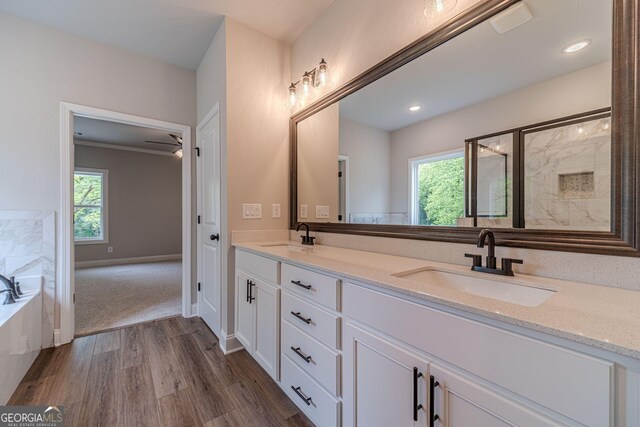 1482 Alcovy Station Rd, Covington, GA 30014 - bathroom featuring wood finished floors, double vanity, a stall shower, a garden tub, and recessed lighting