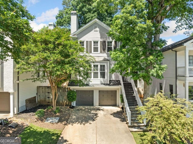 3232 Cates Ave NE, Brookhaven, GA 30319 - view of front of house with stairs, concrete driveway, an attached garage, and a chimney