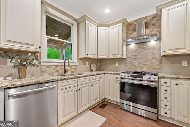 3232 Cates Ave NE, Brookhaven, GA 30319 - kitchen with appliances with stainless steel finishes, wall chimney range hood, cream cabinetry, decorative backsplash, and ornamental molding