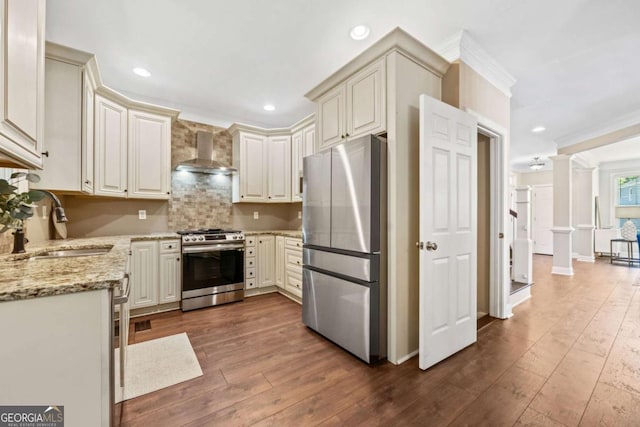 3232 Cates Ave NE, Brookhaven, GA 30319 - kitchen featuring appliances with stainless steel finishes, wall chimney range hood, dark wood-type flooring, light stone counters, and crown molding