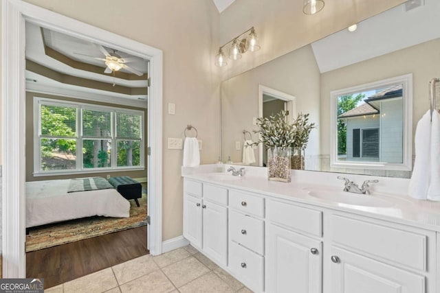 3232 Cates Ave NE, Brookhaven, GA 30319 - ensuite bathroom featuring double vanity, ceiling fan, tile patterned flooring, and a raised ceiling