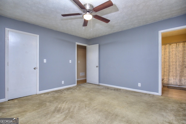 unfurnished bedroom featuring baseboards, carpet flooring, connected bathroom, and a textured ceiling