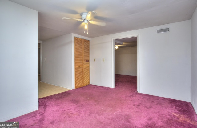 carpeted empty room featuring a ceiling fan