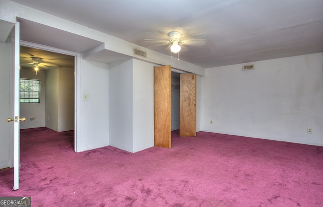 empty room featuring a ceiling fan and carpet
