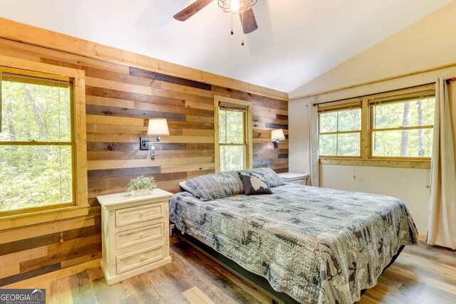162 Little Falls Dr, Mineral Bluff, GA 30559 - bedroom featuring vaulted ceiling, multiple windows, wood walls, light wood-type flooring, and a ceiling fan
