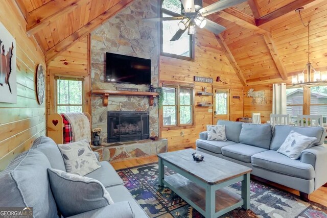 162 Little Falls Dr, Mineral Bluff, GA 30559 - living room featuring wooden ceiling, wooden walls, wood finished floors, a stone fireplace, and ceiling fan