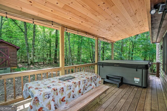 162 Little Falls Dr, Mineral Bluff, GA 30559 - wooden deck featuring a hot tub, a view of trees, and a storage shed