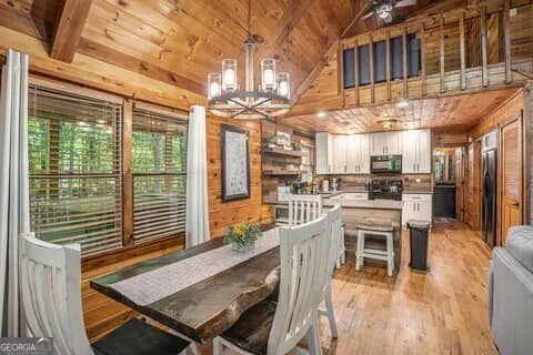 162 Little Falls Dr, Mineral Bluff, GA 30559 - dining space with wooden walls, wood ceiling, a chandelier, and light wood-type flooring