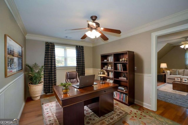 office featuring ceiling fan, wood finished floors, wainscoting, and ornamental molding