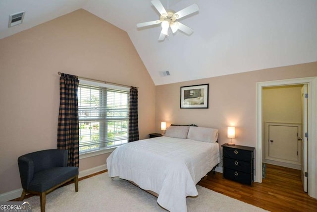 bedroom with vaulted ceiling, wood finished floors, baseboards, and ceiling fan