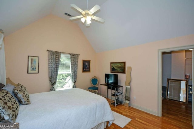 bedroom featuring wood finished floors, vaulted ceiling, ceiling fan, and baseboards