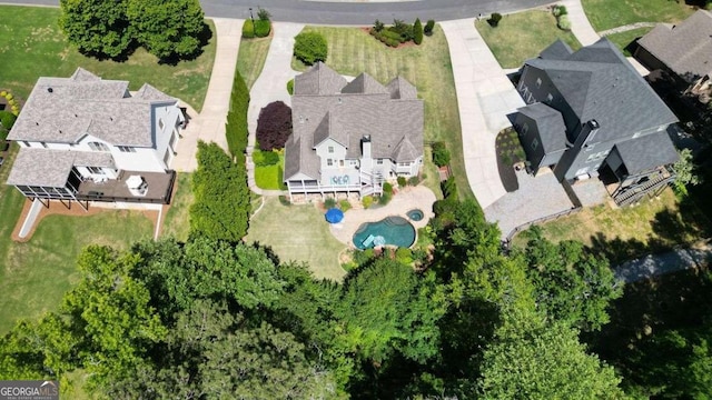 aerial view of property and surrounding area with a pool area and nearby suburban area