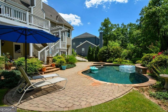 view of pool with a hot tub, a patio area, and stairs