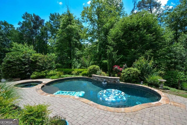 view of pool with a patio area and a pool with connected hot tub