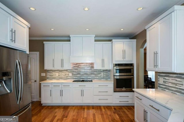 kitchen with stainless steel appliances, tasteful backsplash, crown molding, white cabinetry, and light wood finished floors