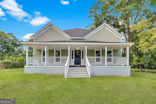 245 N Terrell St, Metter, GA 30439 - view of front facade featuring roof with shingles, a front lawn, covered porch, and board and batten siding