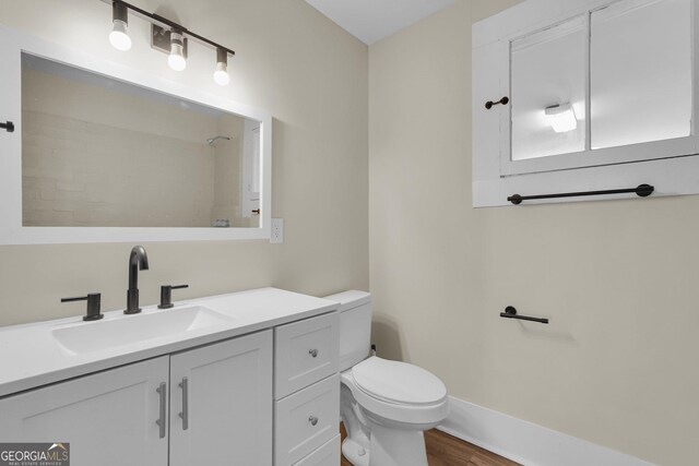 245 N Terrell St, Metter, GA 30439 - bathroom featuring toilet, wood finished floors, vanity, and baseboards