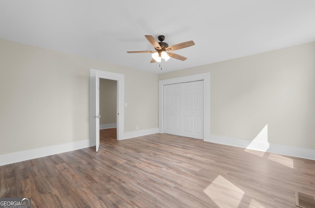 245 N Terrell St, Metter, GA 30439 - unfurnished bedroom with wood finished floors, a closet, baseboards, and a ceiling fan