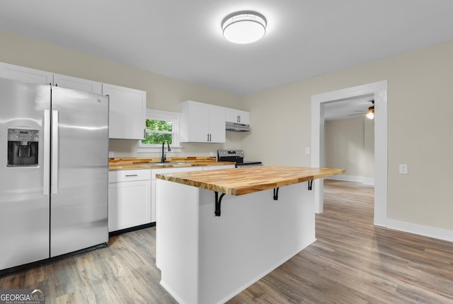 245 N Terrell St, Metter, GA 30439 - kitchen with butcher block counters, appliances with stainless steel finishes, a kitchen breakfast bar, and white cabinets