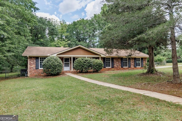 ranch-style home featuring brick siding, a front lawn, and a shingled roof
