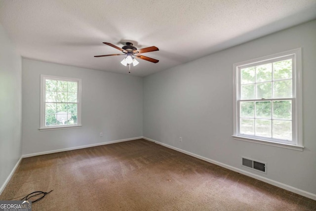 empty room featuring carpet, baseboards, and a textured ceiling