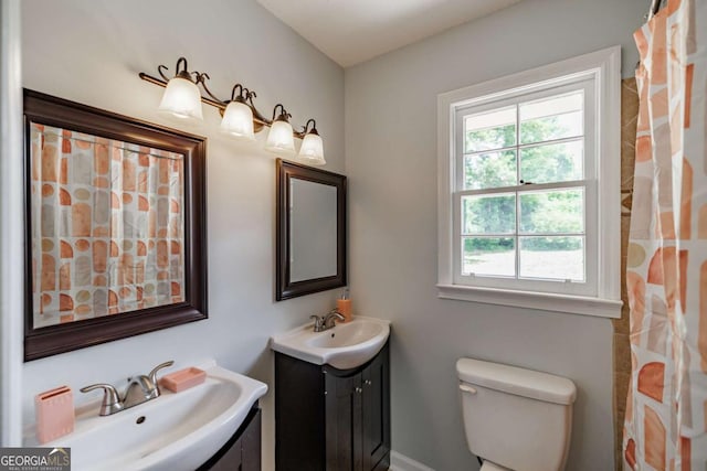 bathroom featuring plenty of natural light, vanity, and toilet