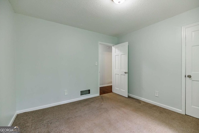 unfurnished bedroom featuring carpet, baseboards, and a textured ceiling