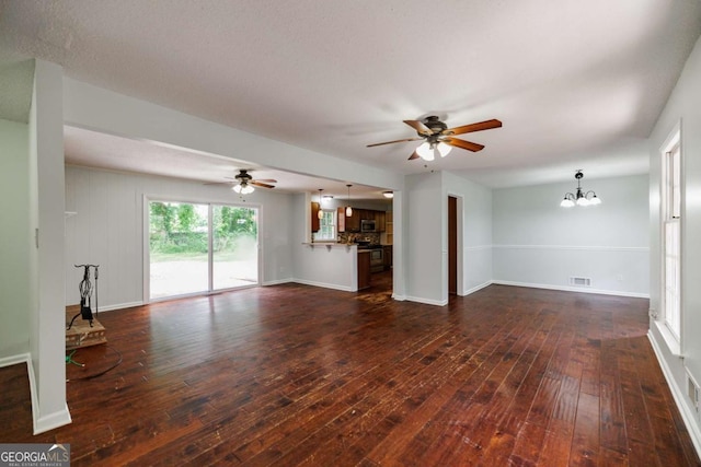 unfurnished living room with ceiling fan, dark wood-style flooring, a chandelier, and baseboards